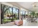 Bright sunroom with large windows offering views of the lake and lush foliage at 226 Southampton Ln # 257, Venice, FL 34293