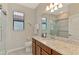 Bathroom with granite countertops, sliding shower door, and natural light from the windows at 24128 Spartina Dr, Venice, FL 34293