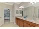 Bathroom featuring a double sink vanity with granite countertop and decorative lighting fixtures at 24128 Spartina Dr, Venice, FL 34293