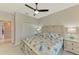 Bedroom with decorative bed, two nightstands, ceiling fan, and closet doors at 24128 Spartina Dr, Venice, FL 34293