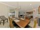 Open dining area with wood table and an industrial light fixture, flowing into the kitchen and living space at 24128 Spartina Dr, Venice, FL 34293