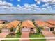 Beautiful exterior showcasing the red tile roof, tropical landscaping, and gorgeous lake view at 24128 Spartina Dr, Venice, FL 34293