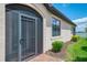 Covered porch with large, screened door and manicured landscaping at 24128 Spartina Dr, Venice, FL 34293
