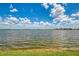 Picturesque lake view with calm waters stretching to the horizon under a bright, cloudy sky at 24128 Spartina Dr, Venice, FL 34293