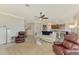 Cozy living room with ceiling fan, leather recliners and view of the kitchen island with breakfast bar at 24128 Spartina Dr, Venice, FL 34293