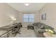Comfortable home office with a gray sectional sofa, desk, and ample natural light creating a cozy workspace at 24128 Spartina Dr, Venice, FL 34293