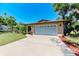 Tan single story house with a two car garage and manicured lawn at 2641 Hyde Park St, Sarasota, FL 34239