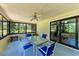 Enclosed sunroom featuring a ceiling fan, a glass table with blue chairs, and great views at 2641 Hyde Park St, Sarasota, FL 34239