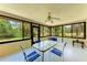 Enclosed sunroom featuring a glass table with blue chairs and large windows with scenic views at 2641 Hyde Park St, Sarasota, FL 34239