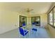 Enclosed sunroom featuring a ceiling fan, table with blue chairs, and glass doors at 2641 Hyde Park St, Sarasota, FL 34239