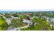 Aerial view showcasing a home nestled amidst lush greenery, with the ocean visible in the distance at 304 Beach Rd, Venice, FL 34285