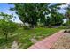 Spacious backyard with a large shade tree and stone accented walkway at 304 Beach Rd, Venice, FL 34285