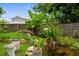 Backyard pond with cascading water feature, lush greenery, and stone bench at 304 Beach Rd, Venice, FL 34285