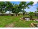Lush backyard with mature trees and a serene koi pond with rock accents at 304 Beach Rd, Venice, FL 34285