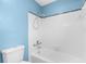 Bathroom featuring a toilet, bathtub, and shower with all white tiles and blue accents at 304 Beach Rd, Venice, FL 34285