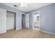 Bright bedroom featuring light blue walls, wood-look tile floors, and a door to an ensuite bathroom at 304 Beach Rd, Venice, FL 34285