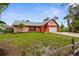 Single-story home featuring a lush green lawn, mature trees, and a convenient two-car garage at 304 Beach Rd, Venice, FL 34285