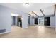 Open living area features wood-look tile, seamlessly connected to the kitchen with black appliances at 304 Beach Rd, Venice, FL 34285