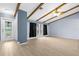 Bright, open-concept living room featuring wood-look tile floors, beamed ceiling, and lots of natural light at 304 Beach Rd, Venice, FL 34285