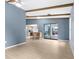 Open-concept living room with wood-look floors, wooden beams, and views of the kitchen and patio at 304 Beach Rd, Venice, FL 34285