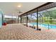 Covered patio and screened pool with brick patio and hanging plants at 304 Beach Rd, Venice, FL 34285