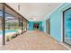 Covered patio with brick flooring, sliding glass doors, and views of the screened-in pool at 304 Beach Rd, Venice, FL 34285