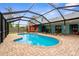 Backyard screened-in pool and brick patio with colorful home in background at 304 Beach Rd, Venice, FL 34285