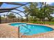 Backyard screened-in pool and brick patio with fenced yard in background at 304 Beach Rd, Venice, FL 34285