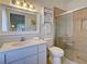 Bright bathroom with a white vanity, framed mirror, and glass-enclosed shower with decorative tile at 3192 Pinetree St, Port Charlotte, FL 33952