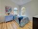 Bedroom featuring wood-look flooring, an arched window, and a blue dresser at 3192 Pinetree St, Port Charlotte, FL 33952