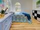 Bedroom featuring wood-look flooring, an arched window, and a blue dresser at 3192 Pinetree St, Port Charlotte, FL 33952