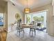 Bright dining area with neutral tile flooring, stylish light fixture, and sliding glass doors to the outdoor patio at 3192 Pinetree St, Port Charlotte, FL 33952