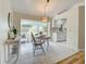 Bright dining area with sliding glass doors to the backyard, light tile floors, and modern lighting at 3192 Pinetree St, Port Charlotte, FL 33952