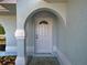 Covered front entryway featuring white pillars, an arched entryway, and light blue exterior paint at 3192 Pinetree St, Port Charlotte, FL 33952