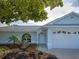 Well maintained single Gathering home with a light blue exterior, inviting entrance, and lush landscaping at 3192 Pinetree St, Port Charlotte, FL 33952