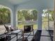 Relax on the screened porch with comfortable seating and a peaceful backyard view at 3192 Pinetree St, Port Charlotte, FL 33952