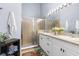 Bright bathroom features a double sink vanity with white cabinets, a glass door shower, and colorful rug at 3419 Lakewood Blvd, North Port, FL 34287