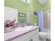 Cozy bathroom features a toilet, a tub with shower, framed art, and a pink countertop at 3419 Lakewood Blvd, North Port, FL 34287