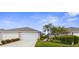 Charming single-story home featuring a two-car garage, well-manicured landscaping, and mature palm trees at 3419 Lakewood Blvd, North Port, FL 34287