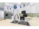 Bright kitchen boasts stainless steel appliances, mosaic backsplash, and white cabinets with decor at 3419 Lakewood Blvd, North Port, FL 34287