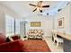 Comfortable living room with a ceiling fan, shuttered windows, and an orange rug at 3419 Lakewood Blvd, North Port, FL 34287