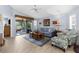 Bright living room with tiled floors, vaulted ceiling, comfortable seating, and a view of the lanai and lake at 3419 Lakewood Blvd, North Port, FL 34287