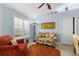 Comfortable living room with a floral sofa, shuttered windows, and an orange rug at 3419 Lakewood Blvd, North Port, FL 34287