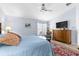 Spacious main bedroom featuring a ceiling fan, shuttered windows, and rich wood furniture at 3419 Lakewood Blvd, North Port, FL 34287