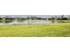 Scenic view of a grassy lawn leading to a peaceful pond in a residential neighborhood at 3419 Lakewood Blvd, North Port, FL 34287