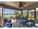 Comfortable screened porch featuring a ceiling fan, plush seating, and a scenic view of the water at 3419 Lakewood Blvd, North Port, FL 34287