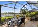 Inviting enclosed porch features table and seating, tile floor and lake views at 3419 Lakewood Blvd, North Port, FL 34287