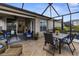 Relaxing screened porch with a dining table, outdoor seating, and peaceful views of the lake at 3419 Lakewood Blvd, North Port, FL 34287