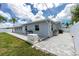 Exterior view of the house with paved walkway, generator, and fenced-in backyard at 379 Peppertree Rd, Venice, FL 34293