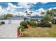 Charming home featuring a well-manicured lawn, landscaped garden, paved driveway and solar panels at 379 Peppertree Rd, Venice, FL 34293